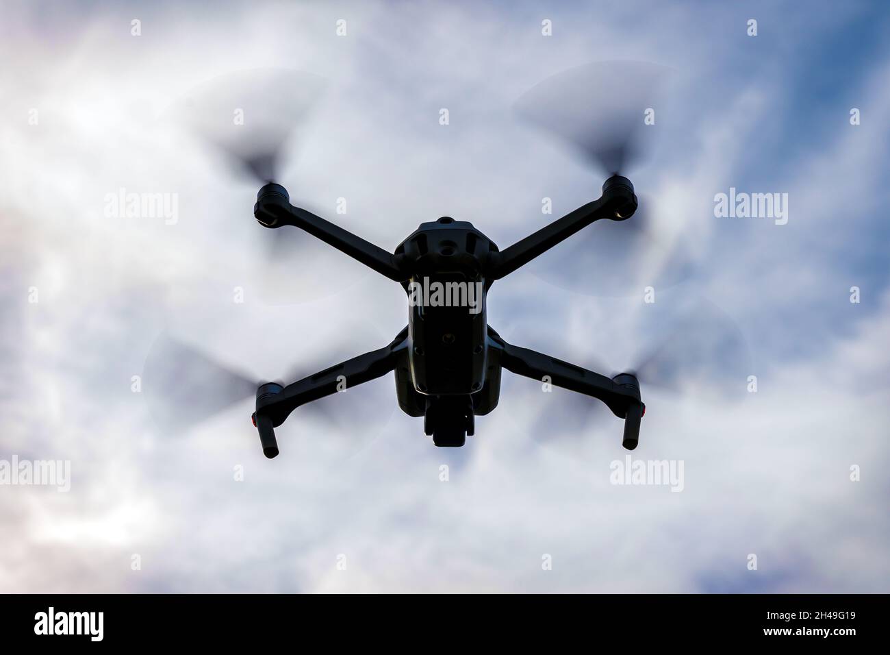 flying drone silhouette on dark cloudy sky background Stock Photo