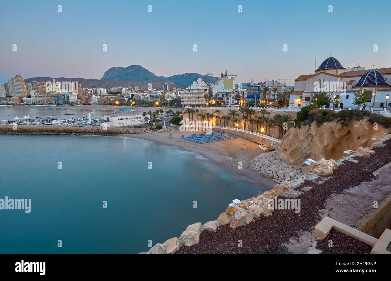 Panorama of Benidorm city with beautiful beach with palm trees over background of mountains. Poniente beach Stock Photo
