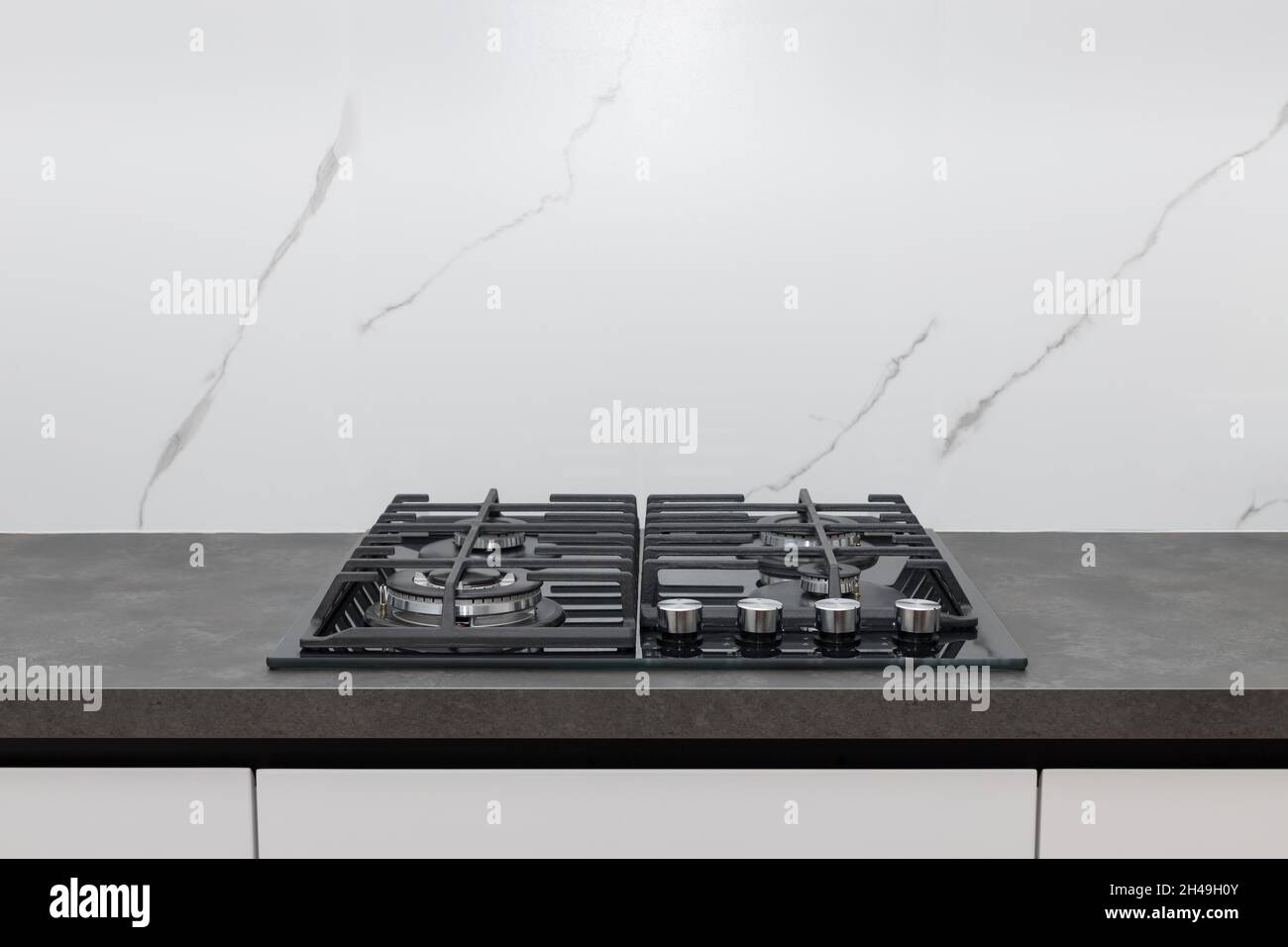 kitchen gas stove on gray worktop and white marble backsplash Stock