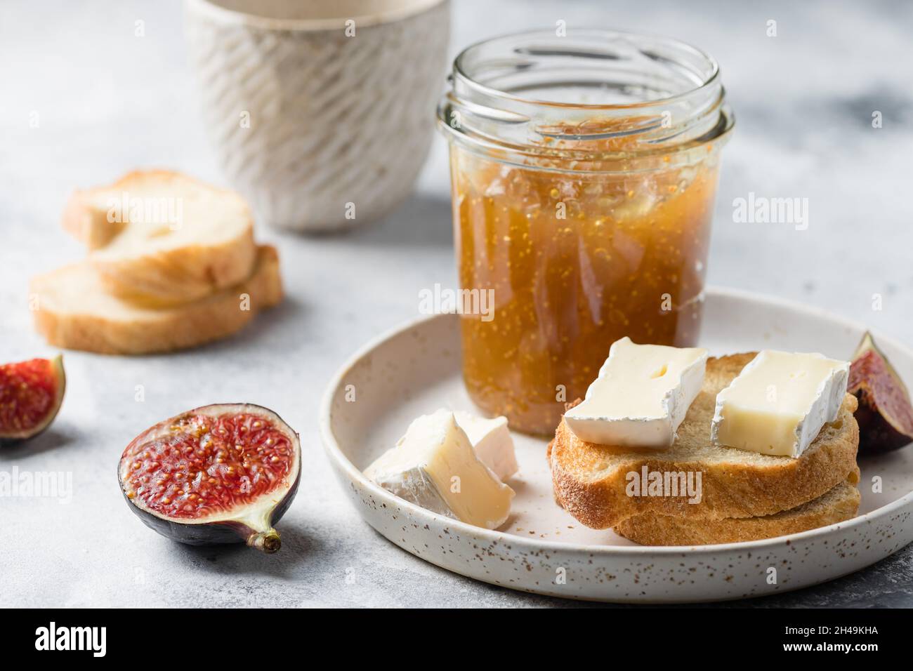 Jar of fig jam and toasted bread with brie cheese Stock Photo