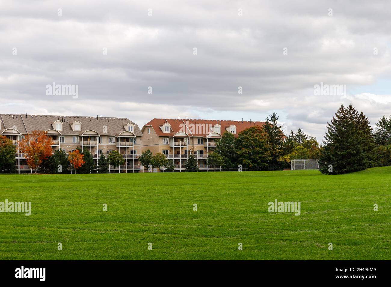 Residential house with apartments or condo building and soccer field