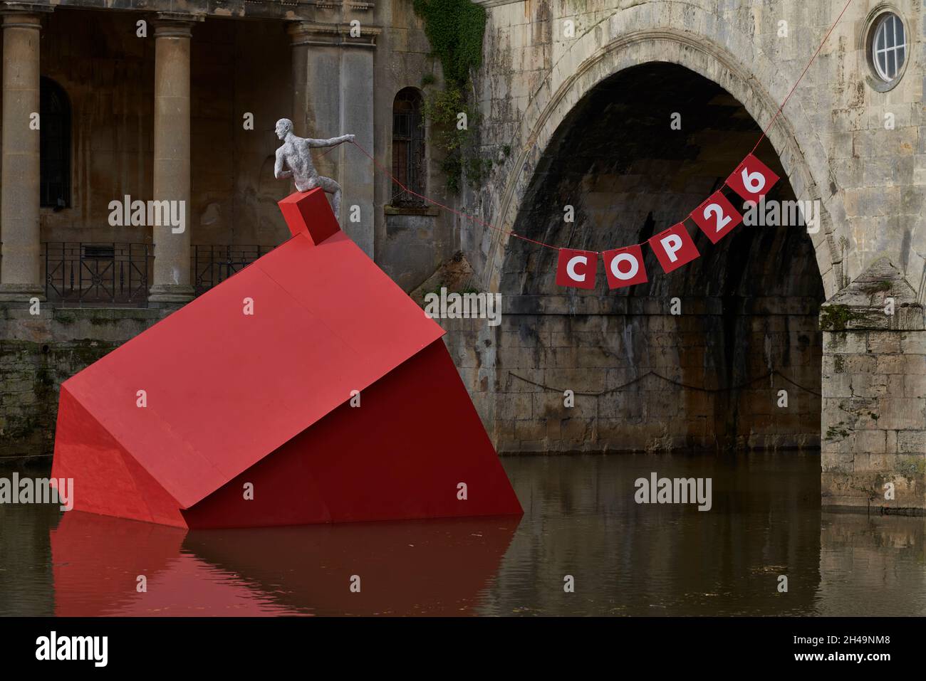 Artwork marking COP26 comprising a red sinking house in the River Avon in the historic city of Bath in the United Kingdom Stock Photo