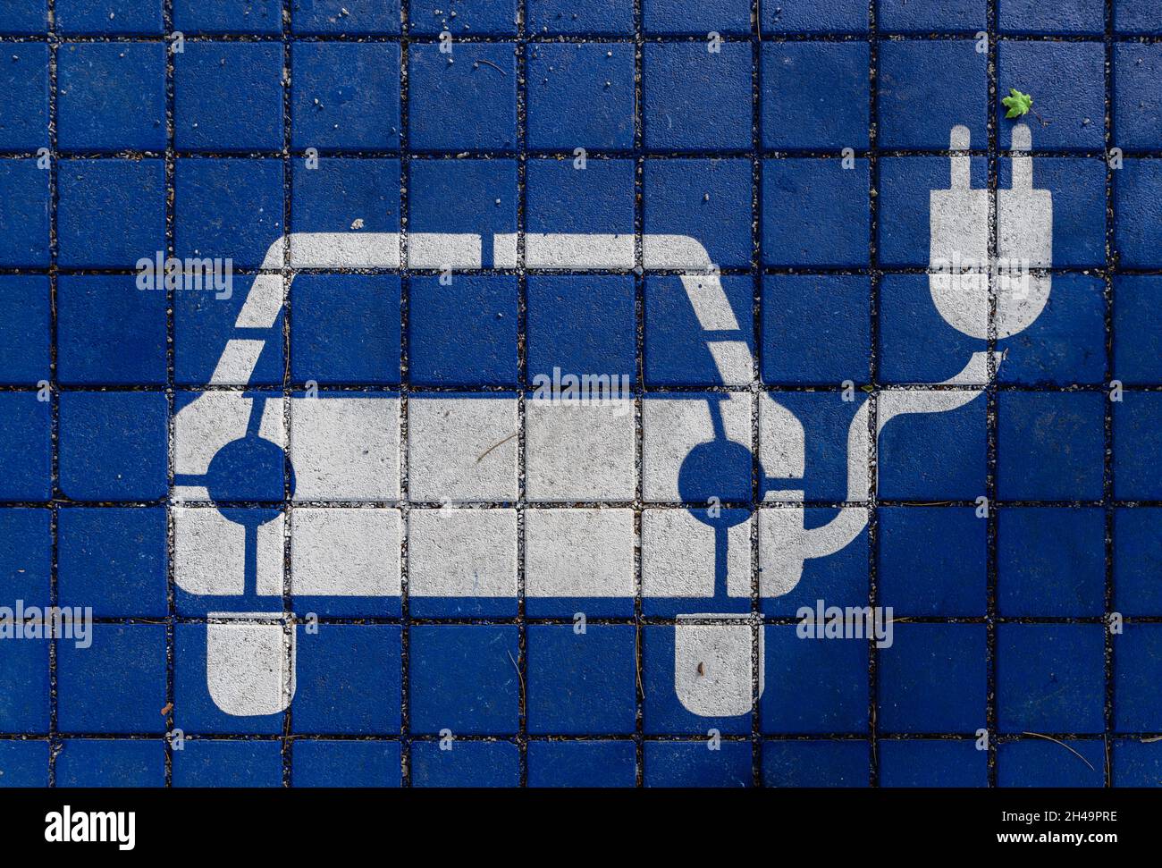 Qfficial charging sign for electic automobiles at paving stones on the ground as concept for the trend of the increasing and future orientated e Stock Photo