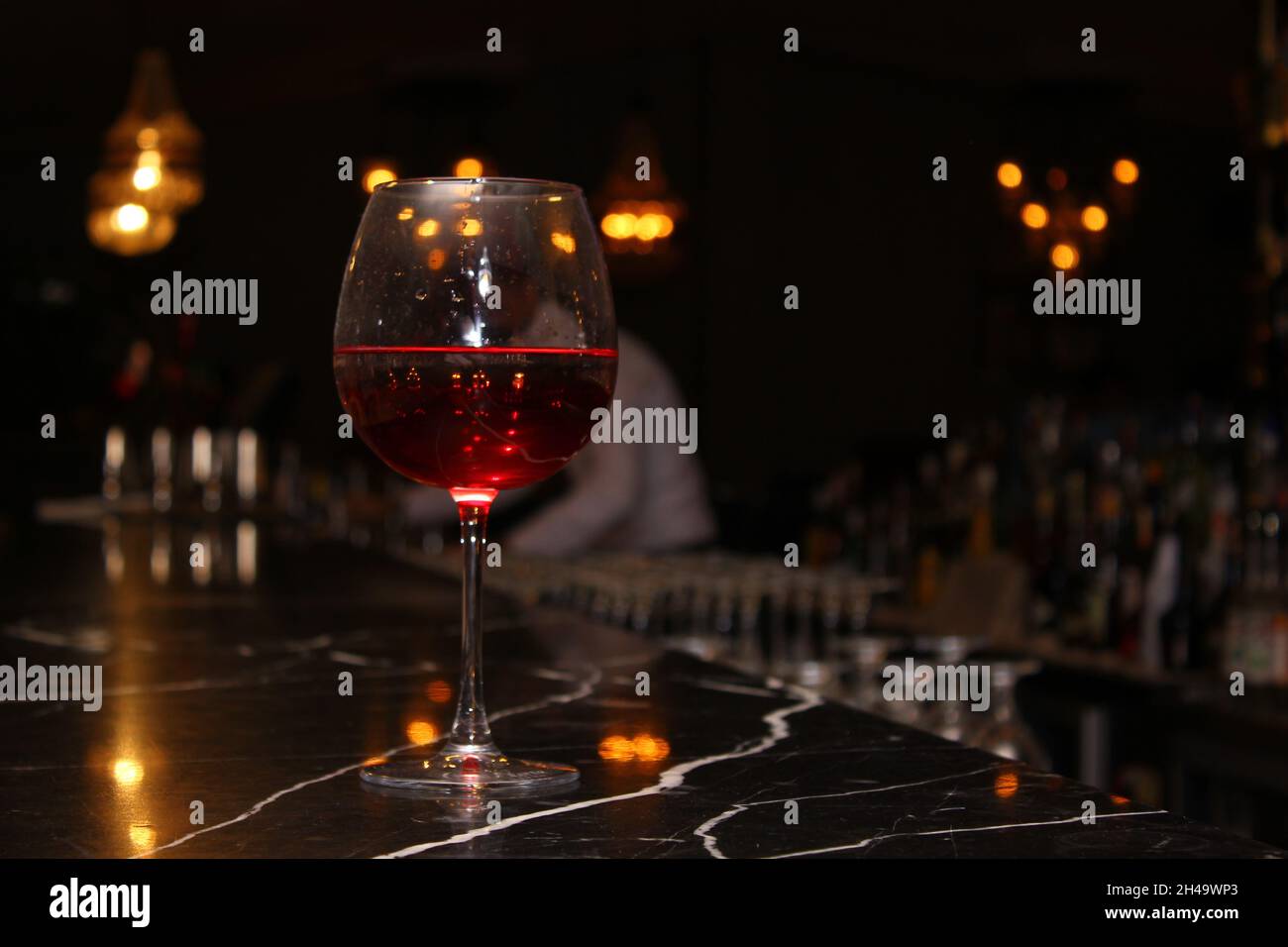 nightlife,bar counter,drinking glass,Red wine,night,wineglass,alcohol,glass,wine,Refreshment,drink,Food and Drink,focus on foreground,glass - material Stock Photo