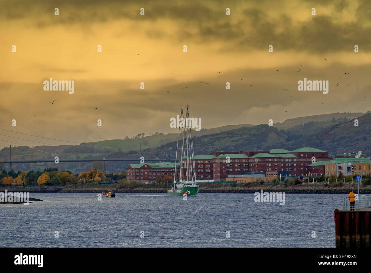 Glasgow, Scotland, UK 1st November, 2021.UK  Weather: Rainbow warrior passed under the erskine bridge into the clyde and by the clyde titan old shipbuilding crane where the great clyde liners were built  waved on by onlookers in clydebank escorted by rnli rubber dingy and a helicopter. .  Credit: Gerard Ferry/Alamy Live News Stock Photo