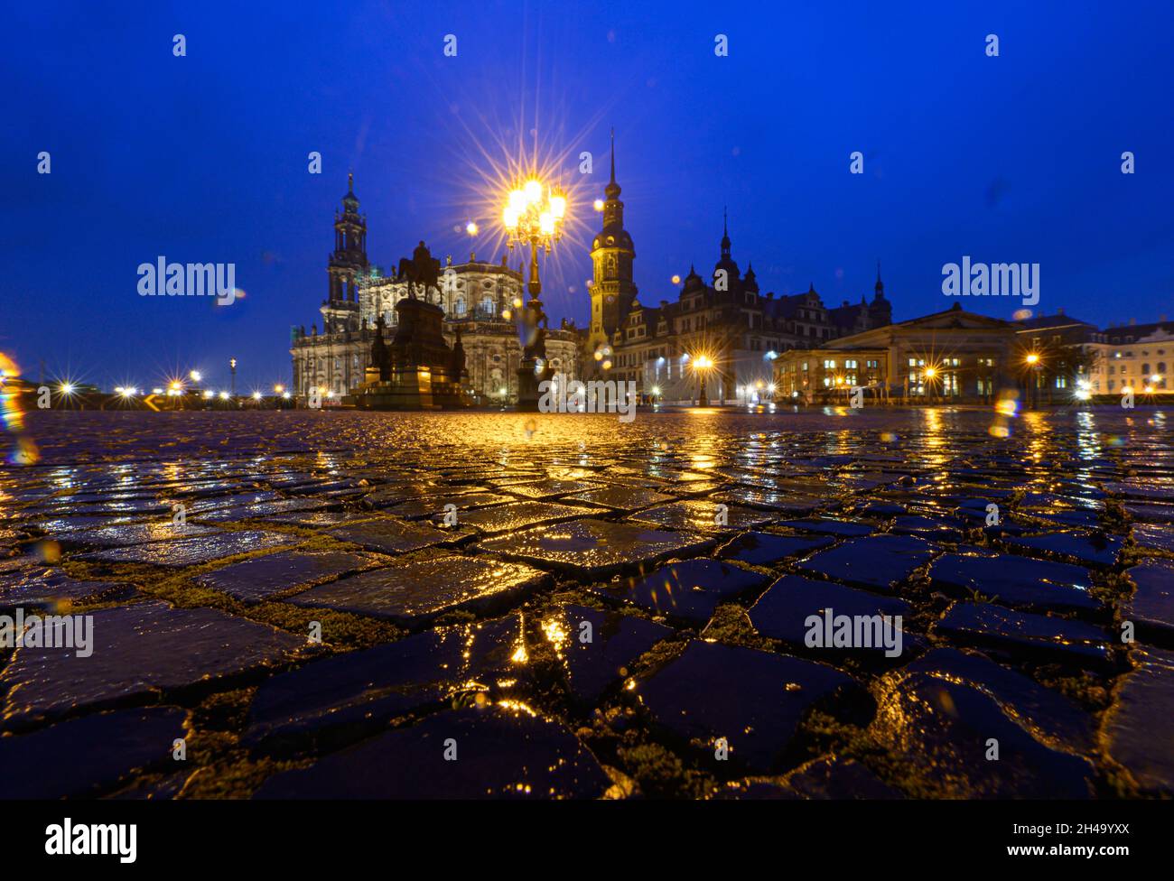 Dresden, Germany. 01st Nov, 2021. The paving stones on Theaterplatz in front of the Hofkirche (l-r), the equestrian statue of King Johann, the Hausmannsturm, the Residenzschloss and the Schinkelwache are wetted by the rain. Credit: Robert Michael/dpa-Zentralbild/dpa/Alamy Live News Stock Photo