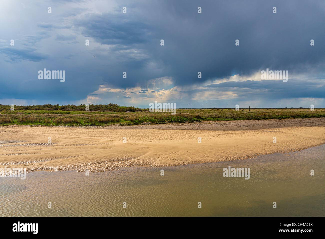 A rain storm approaching the River Glaven on the Blakeney National Nature Reserve at Blakeney, Norfolk UK Stock Photo