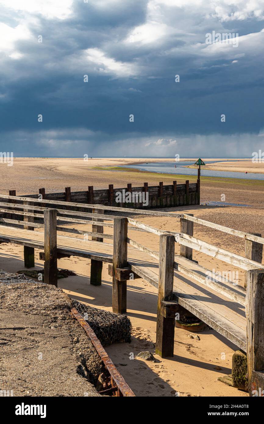 A rain storm over the sea on the beach at Wells next the Sea, Norfolk UK Stock Photo