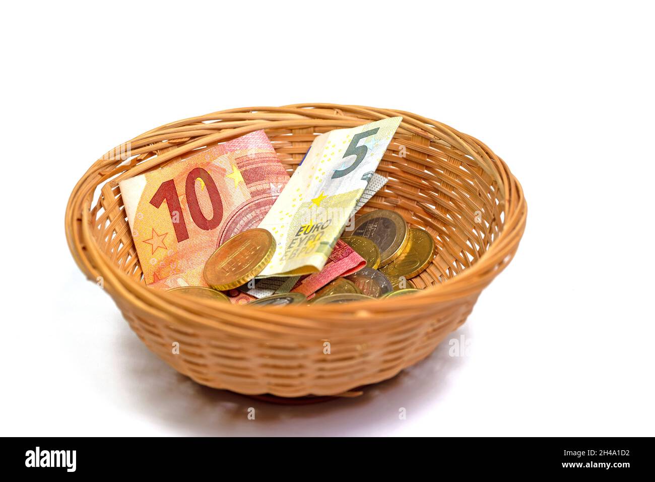 Banknotes and coins in the basket for money collection Stock Photo