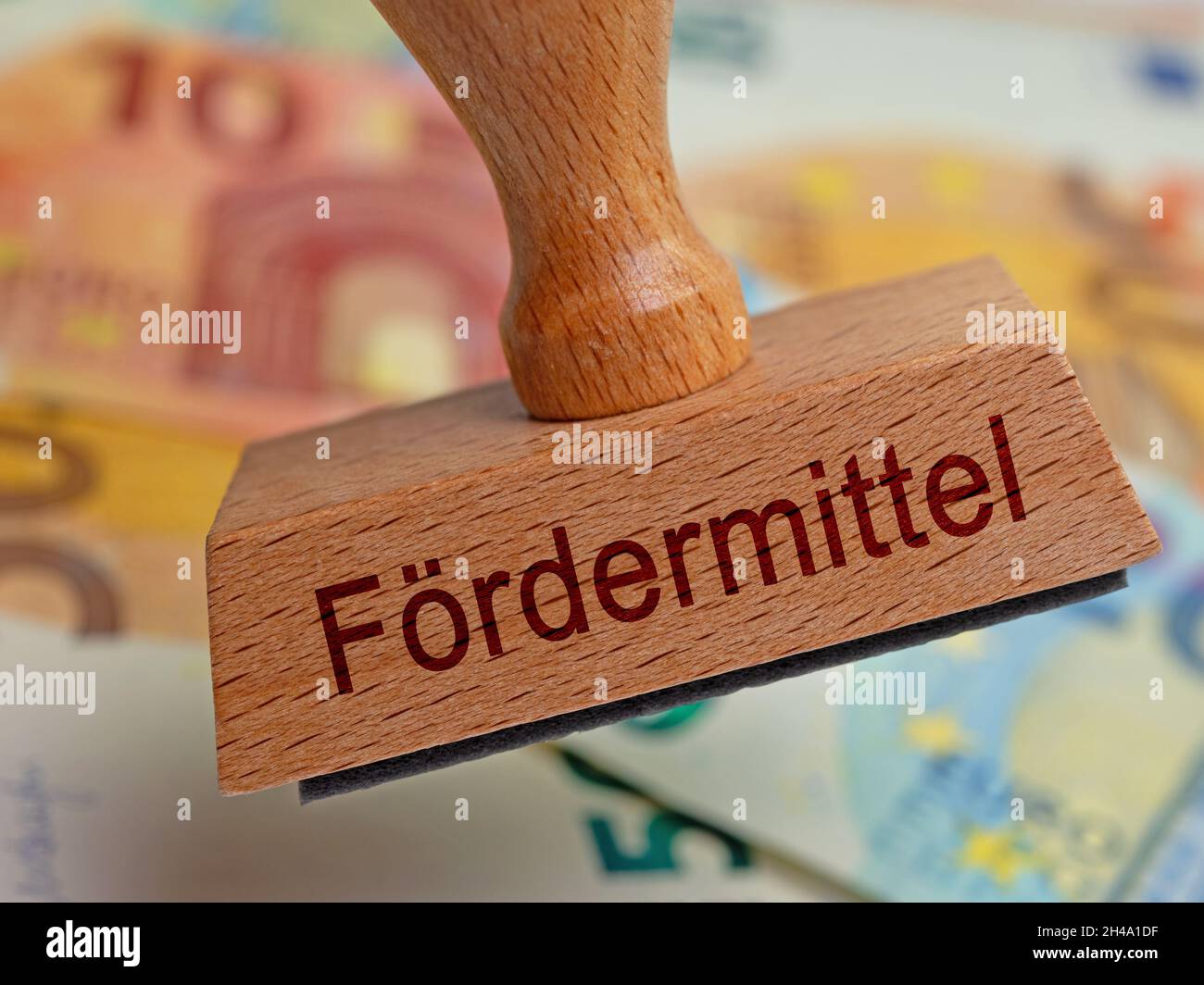 Wooden stamp with the inscription 'Fördermittel' , translation 'Sponsorship' Stock Photo