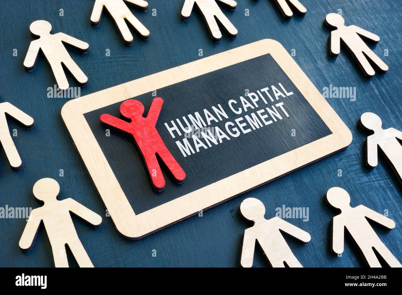 Plate with words Human capital management and red figurine. Stock Photo