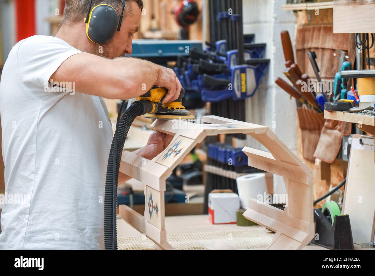 A man is making bespoke furniture in a woodwork showing the construction process Stock