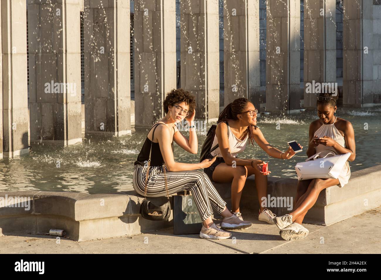 Three adolescent attractive black girls talking and screen sharing Stock Photo