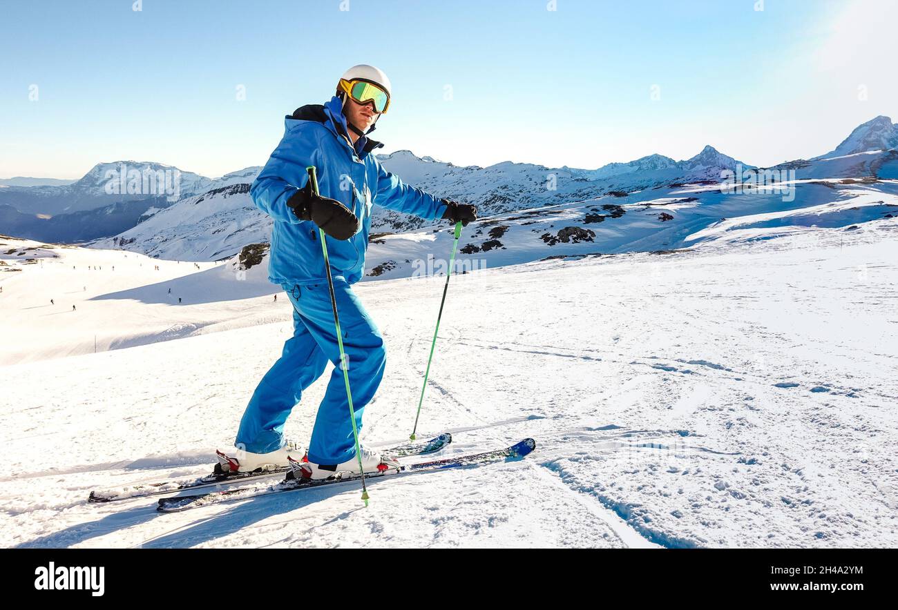 Expert skier on blue uniform on relax moment at french alps ski resort - Winter adventure and sport concept with professional guy on mountain top Stock Photo