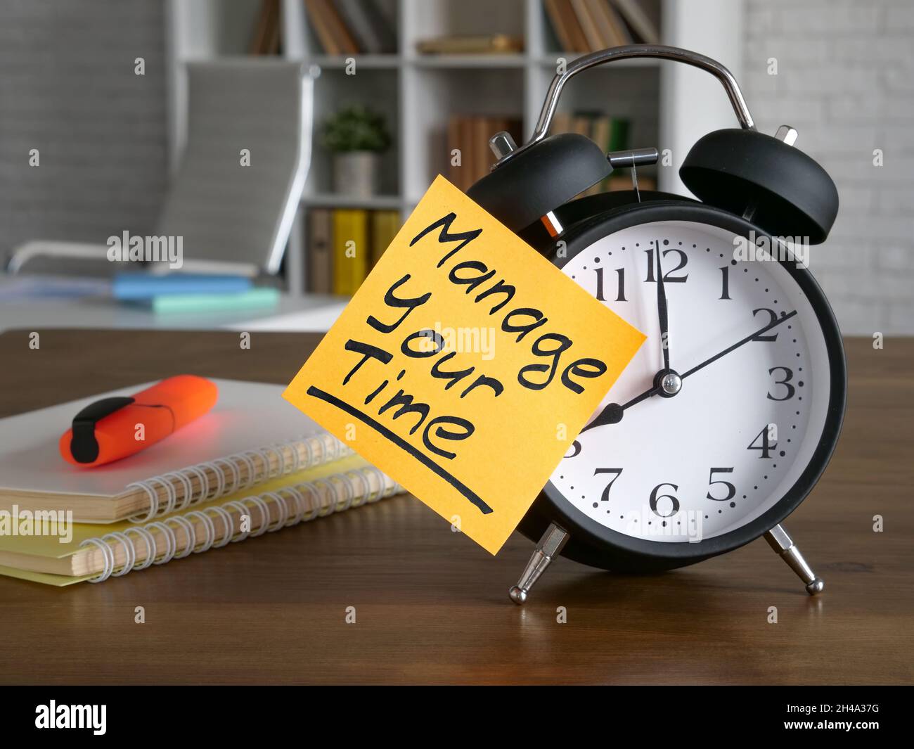 Sticker on the alarm clock with inscription Manage your time. Stock Photo