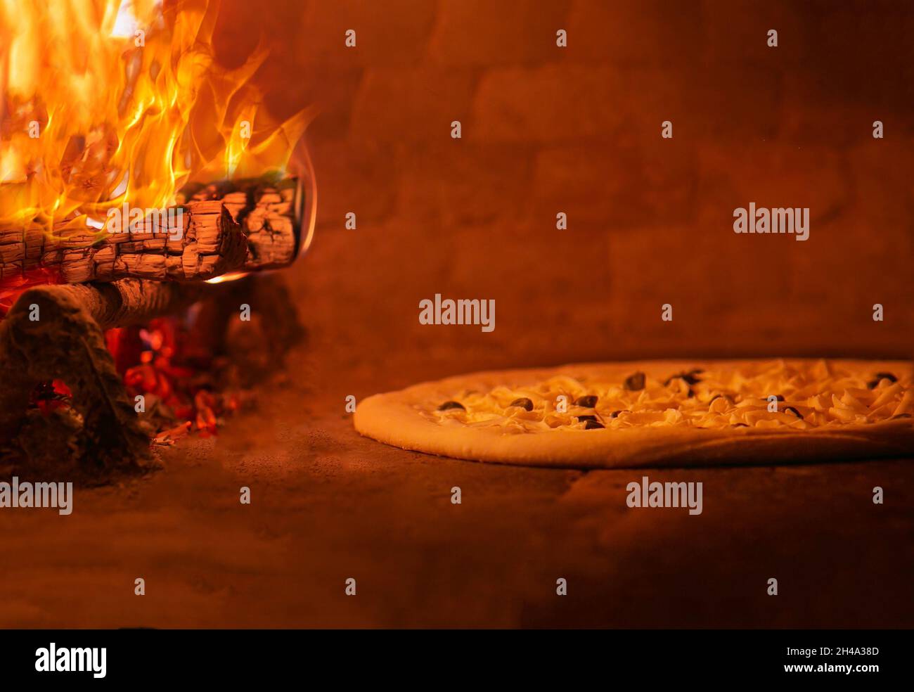 pizza near the fire in oven burning in flames Stock Photo