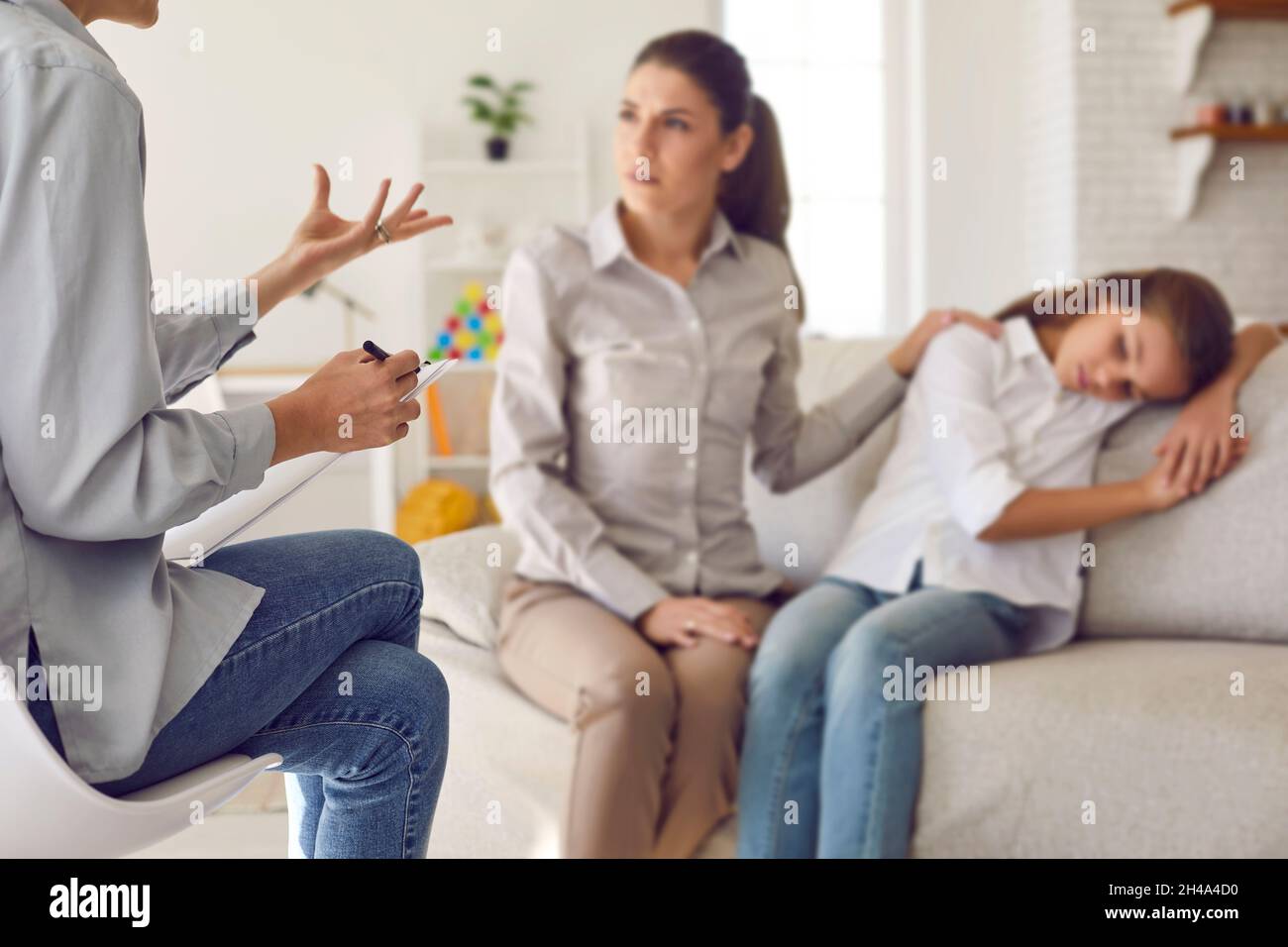 Therapist or psychologist providing professional guidance to mother with her child Stock Photo
