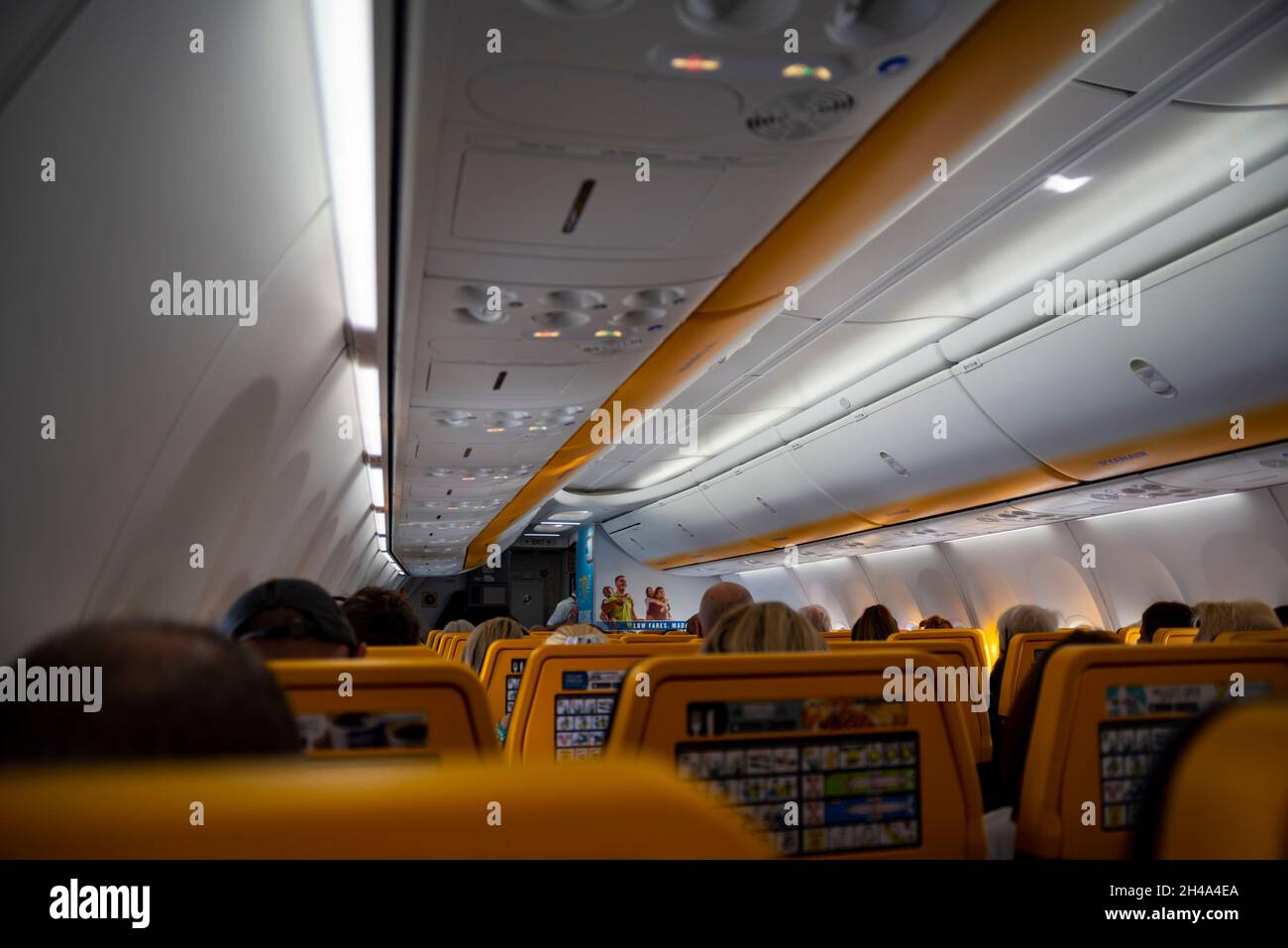 Inside the passenger cabin of a Ryanair Boeing 737 airliner jet plane, with seats and passengers. Flying in Europe. Plane cabin interior Stock Photo