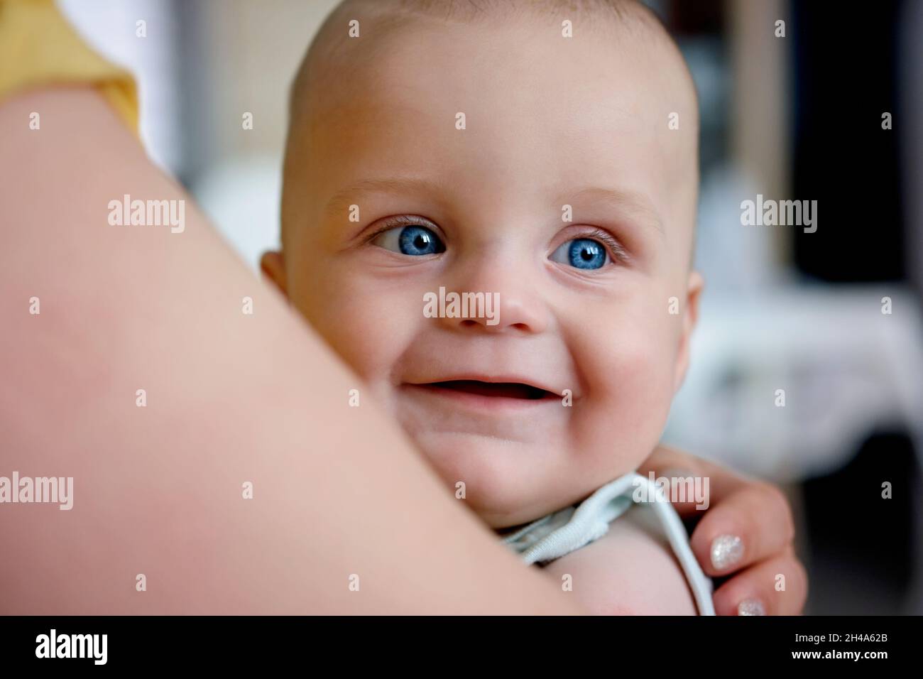portrait of a cute smiling baby with blue eyes looking away Stock Photo
