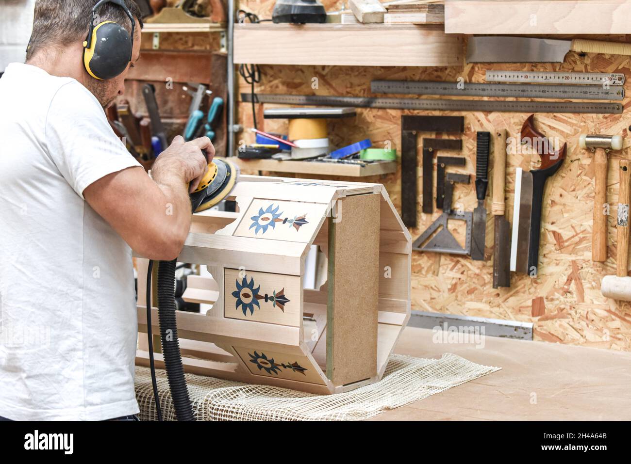 A man is making bespoke furniture in a woodwork showing the construction process Stock