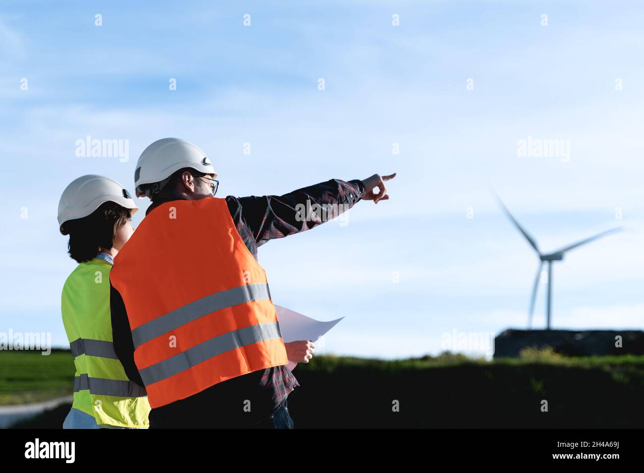 Sustainable energy workers - Engineer people working at alternative energy renewable wind farm Stock Photo