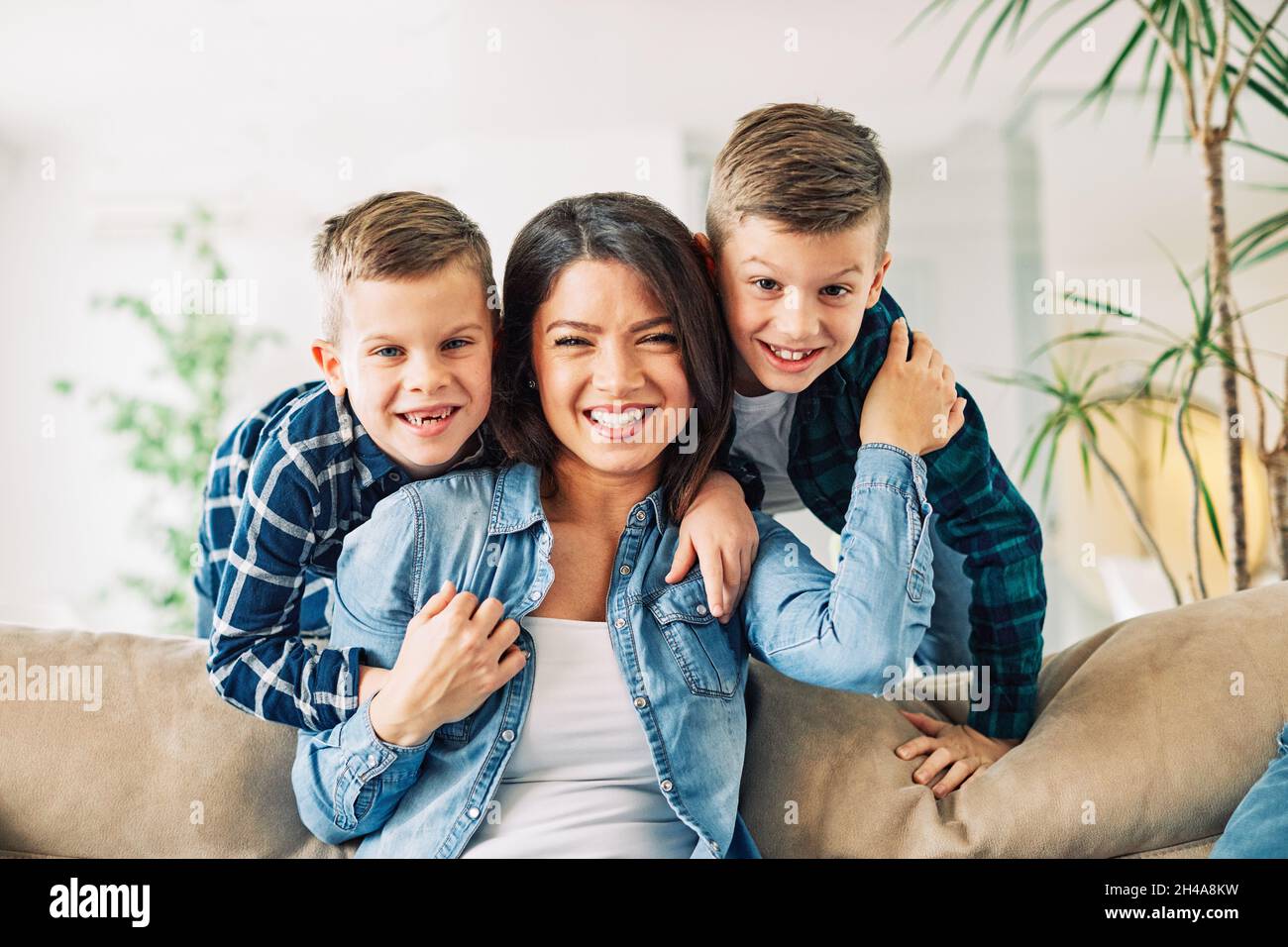 child son mother family happy playing kid childhood mom love fun smiling little woman home brother parent Stock Photo