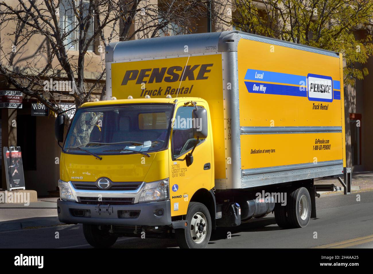 A deliveryman driving a rented Penske truck makes deliveries in
