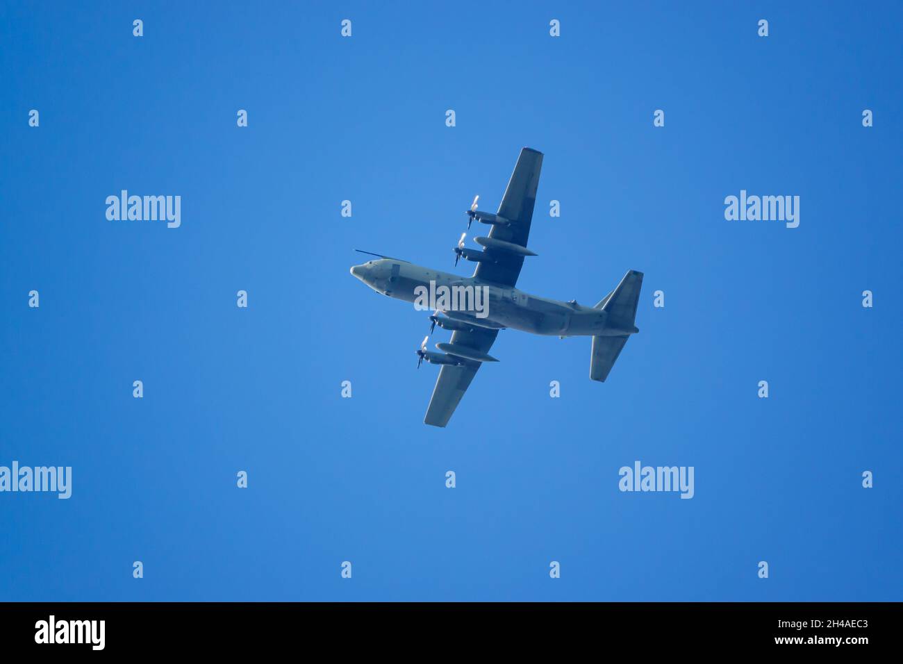 Lockheed Martin C-130J Super Hercules UK Royal Air Force air refueling aircraft flying overhead in clear deep blue sky, Wiltshire UK Stock Photo