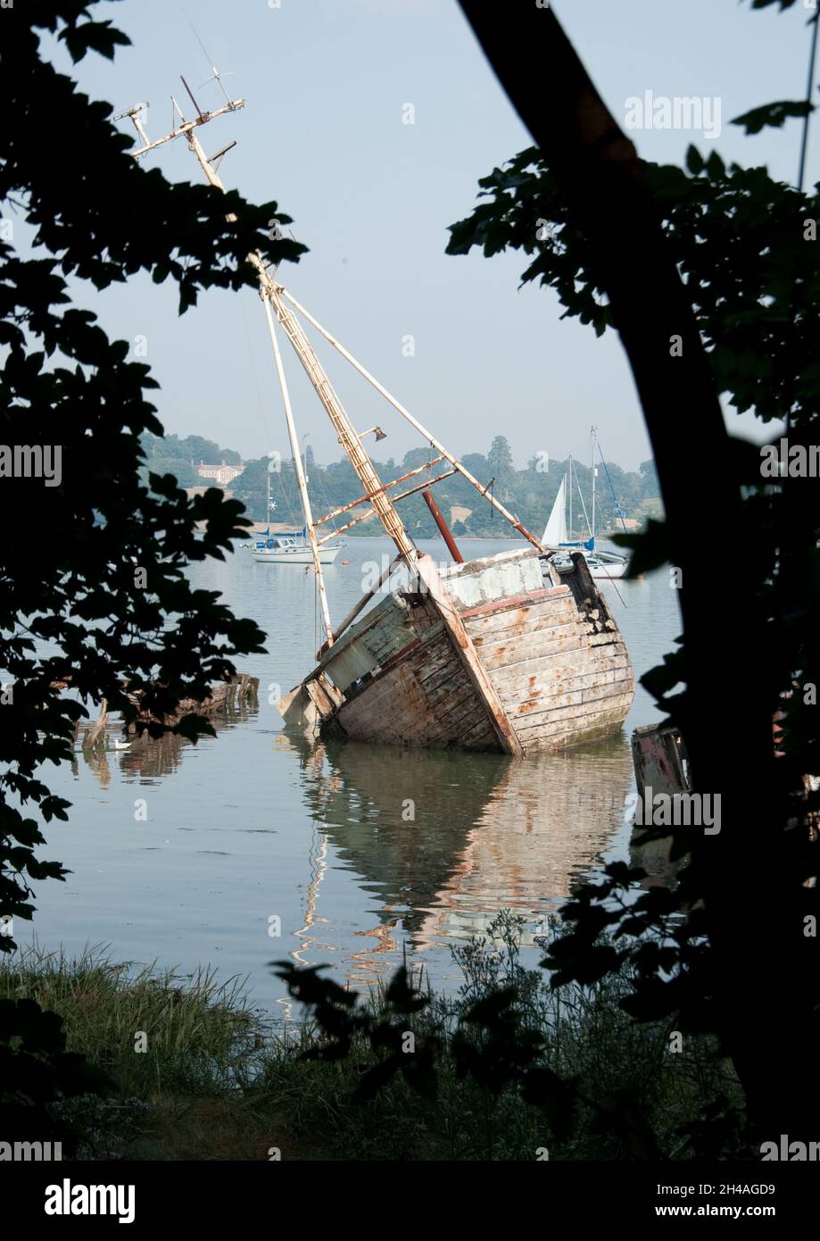 Ruined Boat on the River Orwell at Pin Mill, Suffolk, UK.  Badly damaged boat capsized. Stock Photo