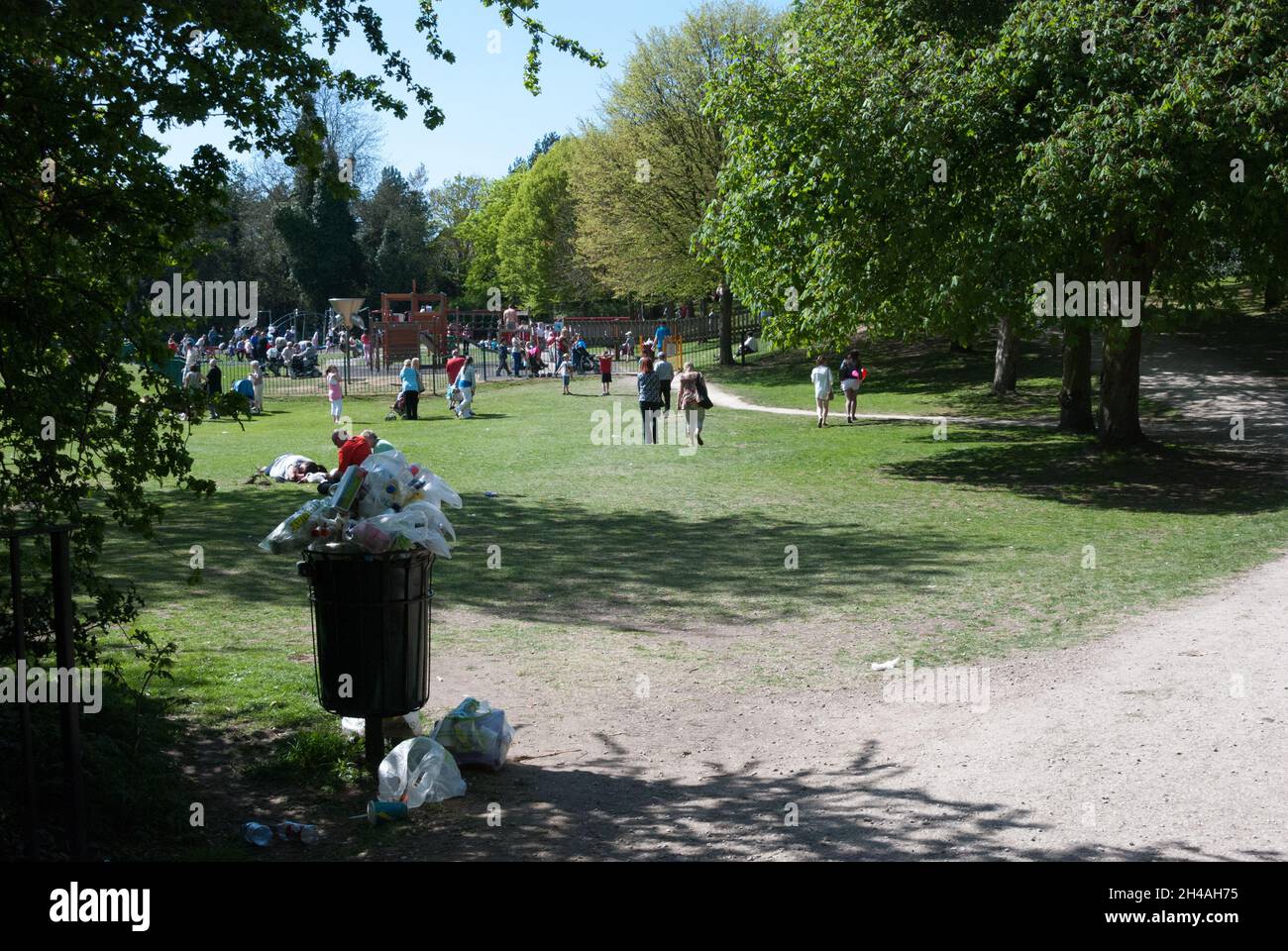 Overflowing Public Rubbish Bin at a Park, People at a Park Stock Photo