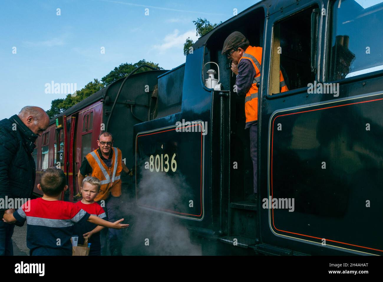 Adult and children enjoying a steam train with friendly train drivers, The Moorlander 8136, Grosmont station, North York Moors heritage railway, UK Stock Photo
