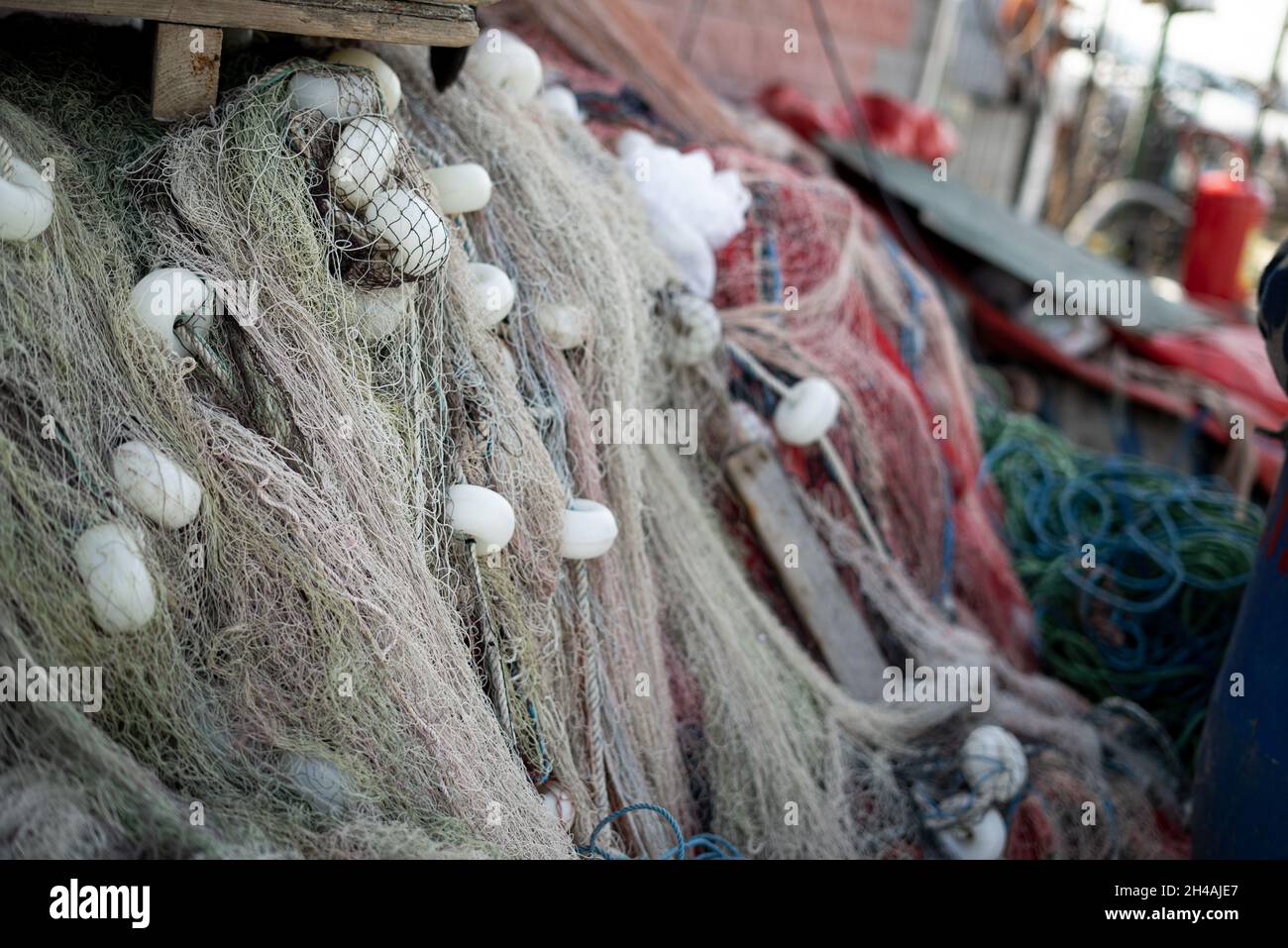 https://c8.alamy.com/comp/2H4AJE7/stacked-fishing-nets-and-ropes-red-green-blue-and-white-2H4AJE7.jpg