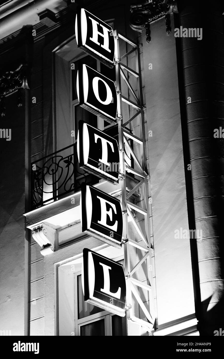 Vertical grayscale shot of a Hotel sign on the bui Stock Photo
