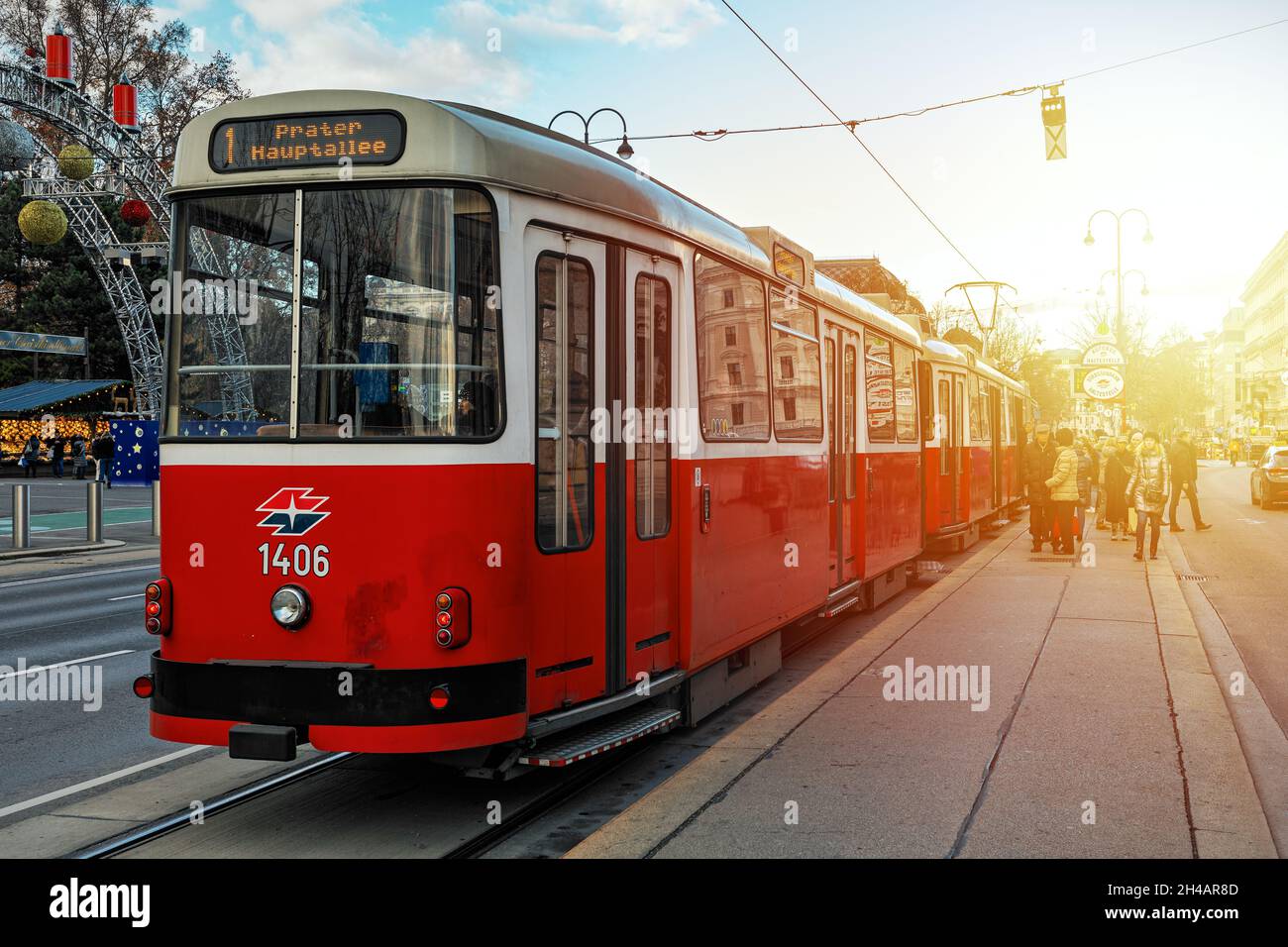 Old fashioned red tram at the stop on the street of Vienna - capital and largest city of Austria. Stock Photo