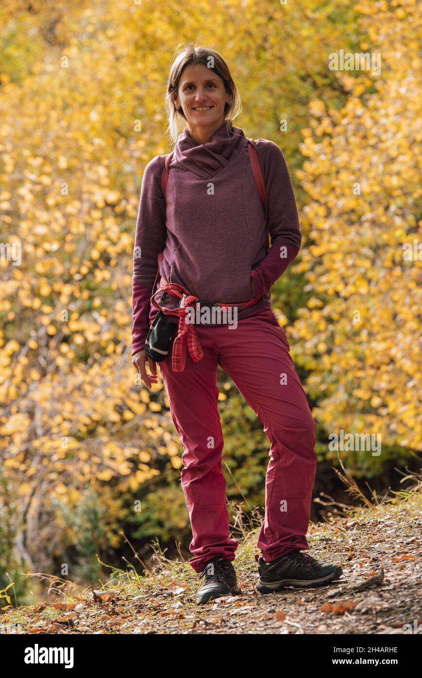 Young woman wearing trekking clothes in the forest in autumn Stock