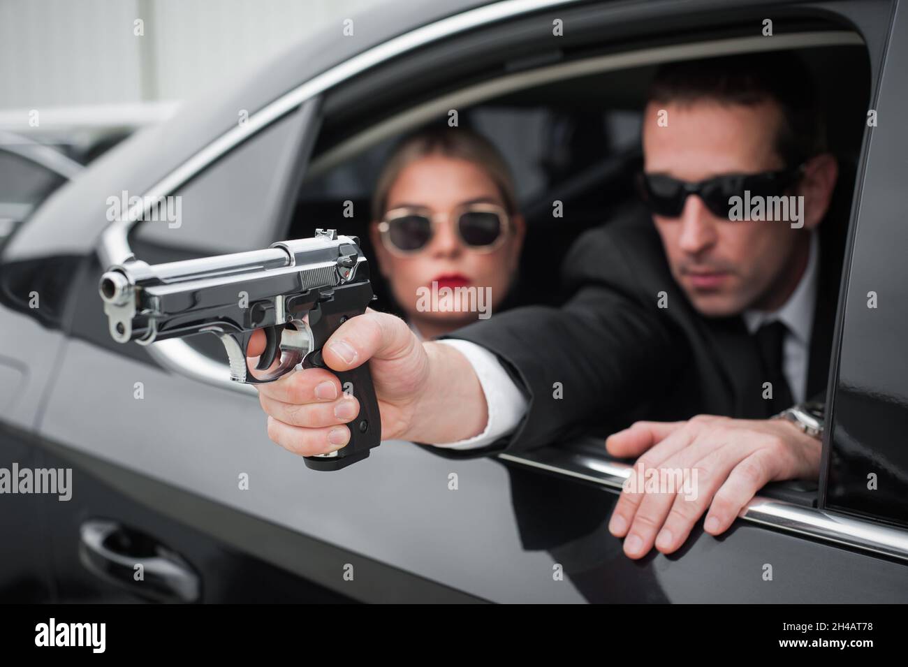 Agent in civilian black suit with gun protect celebrity person in the