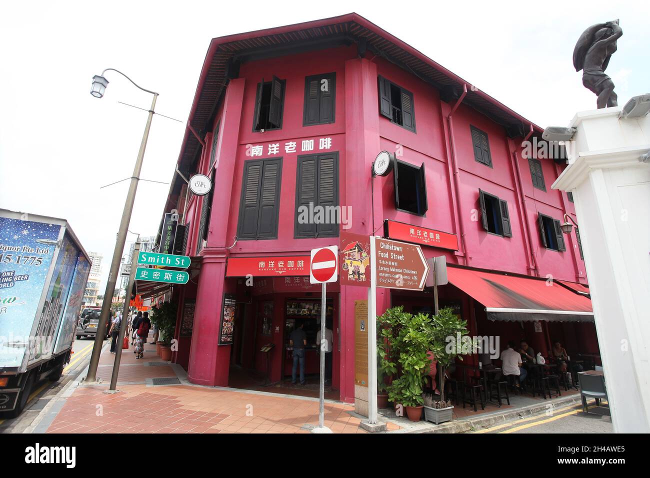 An old red shop house building with brown window shutters iand street name sign for Smith Street in Singapore's Chinatown district. Stock Photo