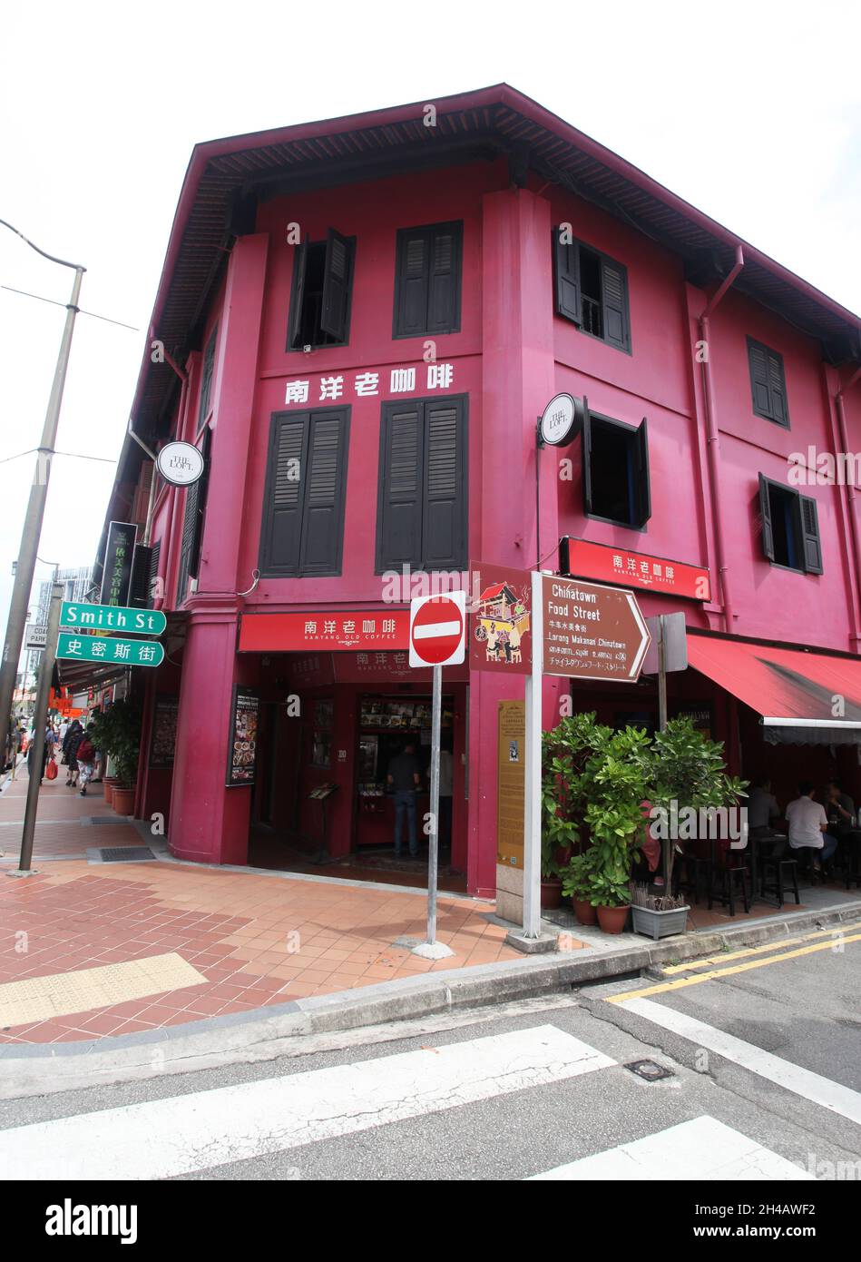 An old red shop house building with brown window shutters iand street name sign for Smith Street in Singapore's Chinatown district. Stock Photo