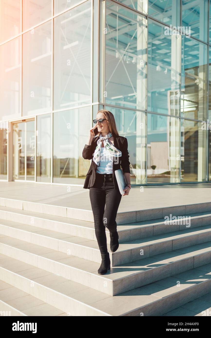 Young business woman in hurry talking on mobile phone on stairs Stock Photo