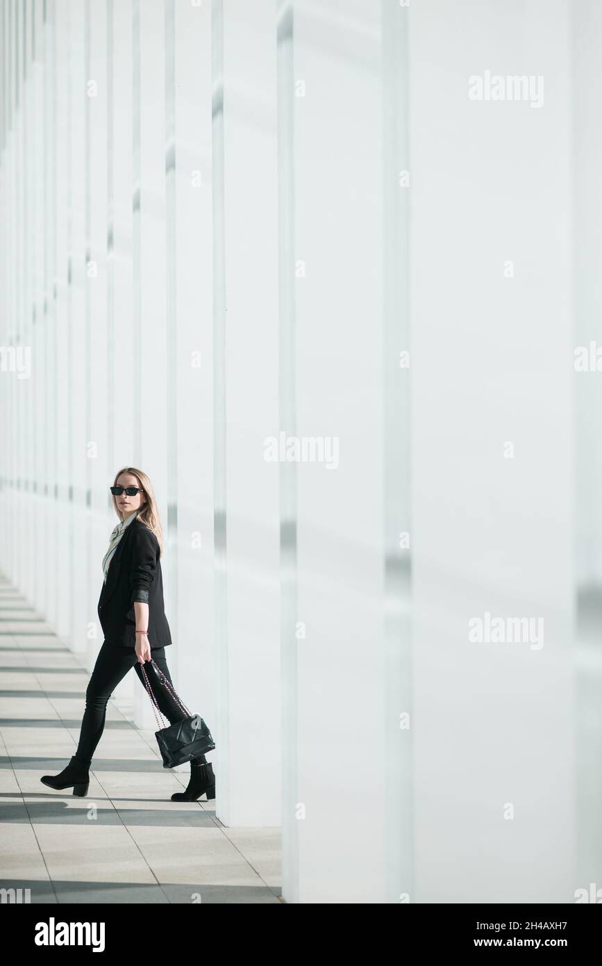 Beautiful young businesswoman walking outside corporate building Stock Photo