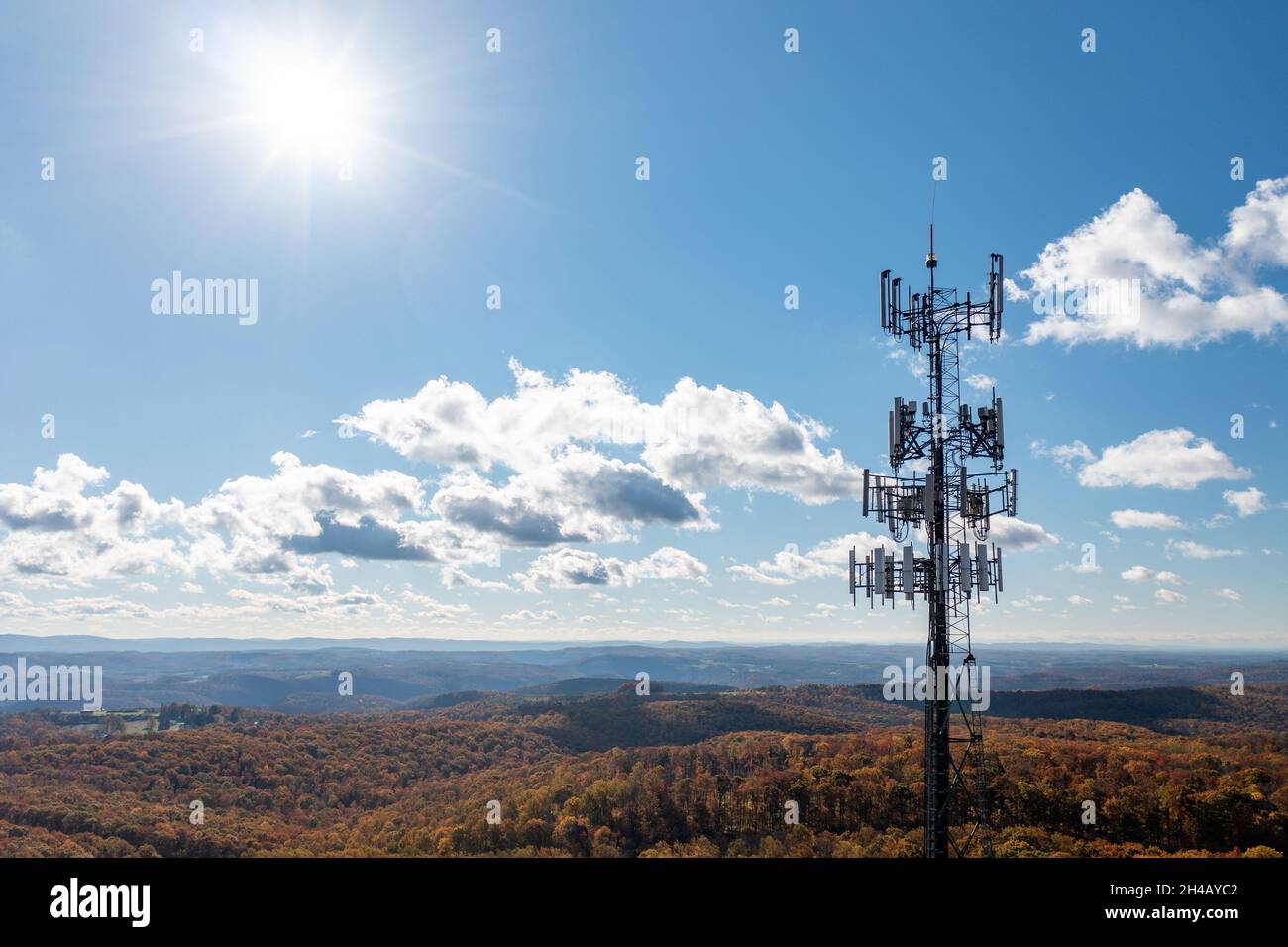 Aerial view of mobile phone cell tower over forested rural area of West