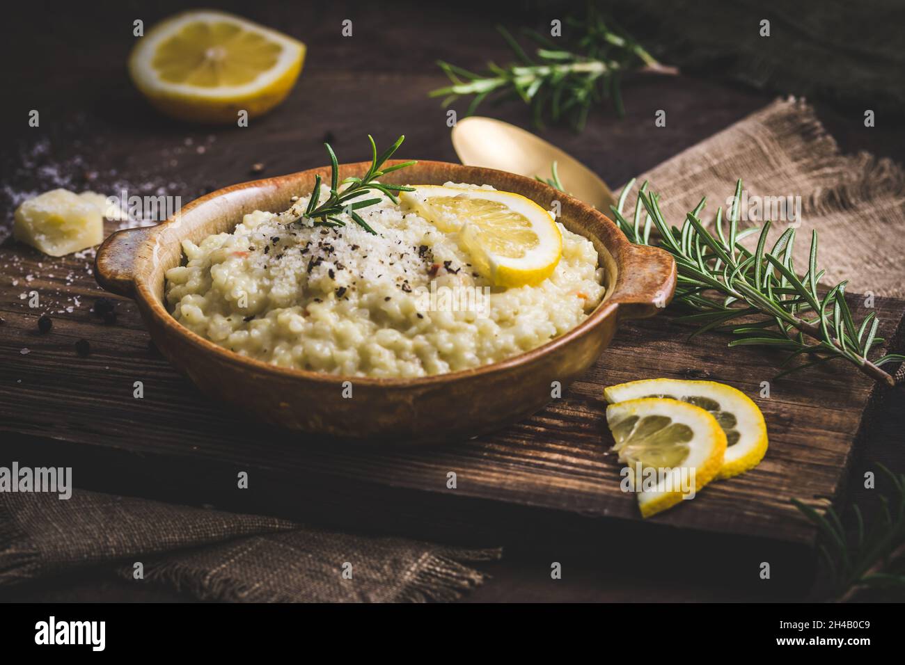 Lemon rice risotto with rosemary on dark wooden background Stock Photo