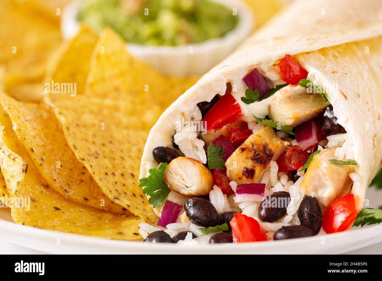 Closeup of a chicken and black bean burrito with tortilla chips Stock