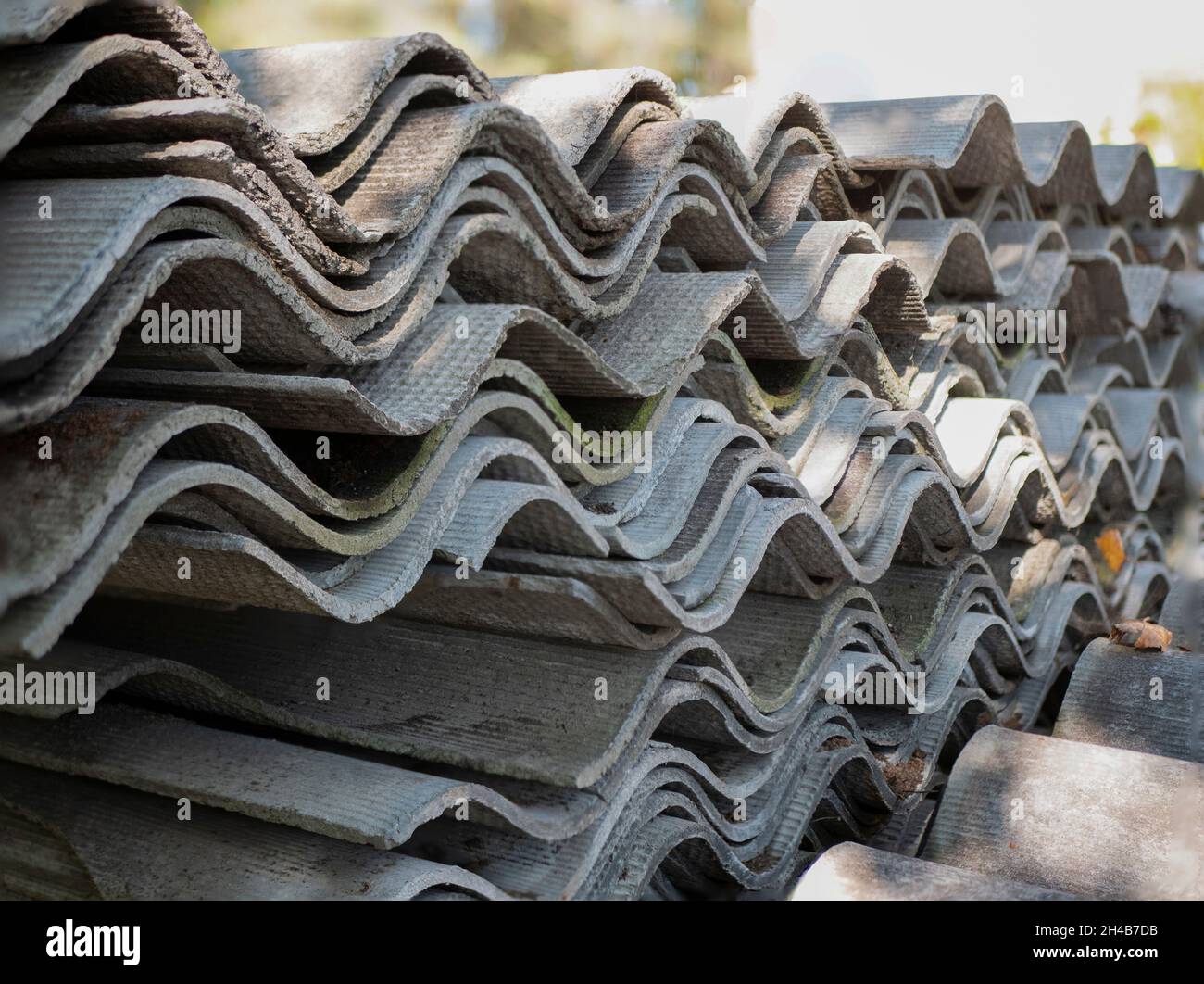 Stacked sheets of slate. Corrugated asbestos-cement sheets. Health-threatening roofing materials Stock Photo