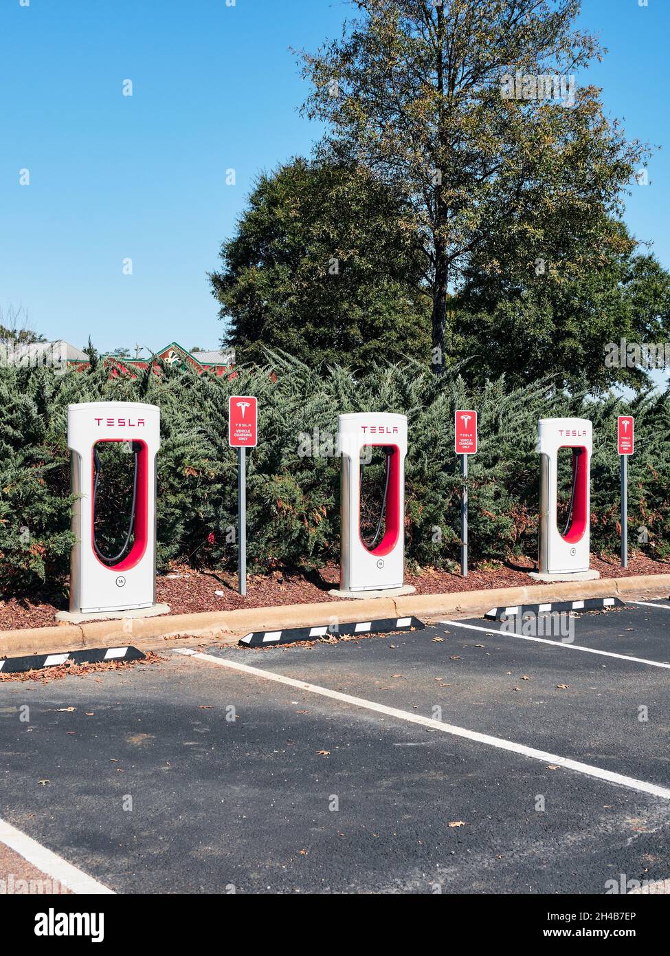 Tesla electric car charging stations for eco friendly cars in a shopping center parking lot in Montgomery Alabama, USA. Stock Photo