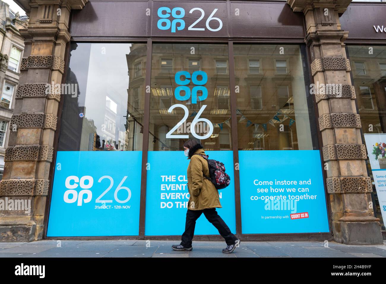 Glasgow, Scotland, UK. 1st November 2021. Images from Monday at the UN climate change conference in Glasgow. Pic; Member of public walks past Coop supermarket hat has been subtly rebranded as a COP26 supermarket in central Glasgow.  Iain Masterton/Alamy Live News. Stock Photo