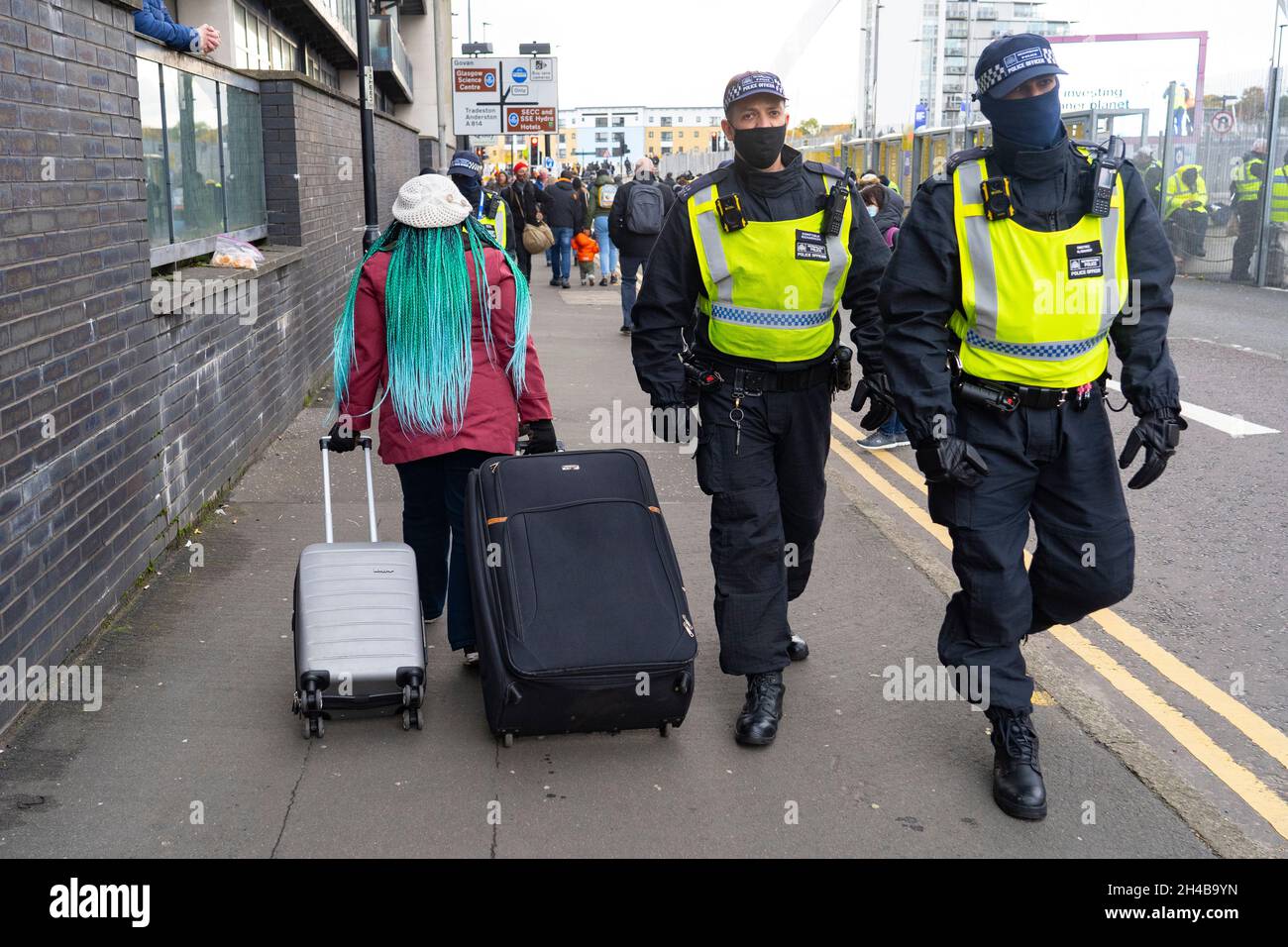 Glasgow, Scotland, UK. 1st November 2021. Images from Monday at the UN climate change conference in Glasgow. Pic; Delegate with suitcases arrives at COP26 venue as London Metropolitan police walk past.  Iain Masterton/Alamy Live News. Stock Photo