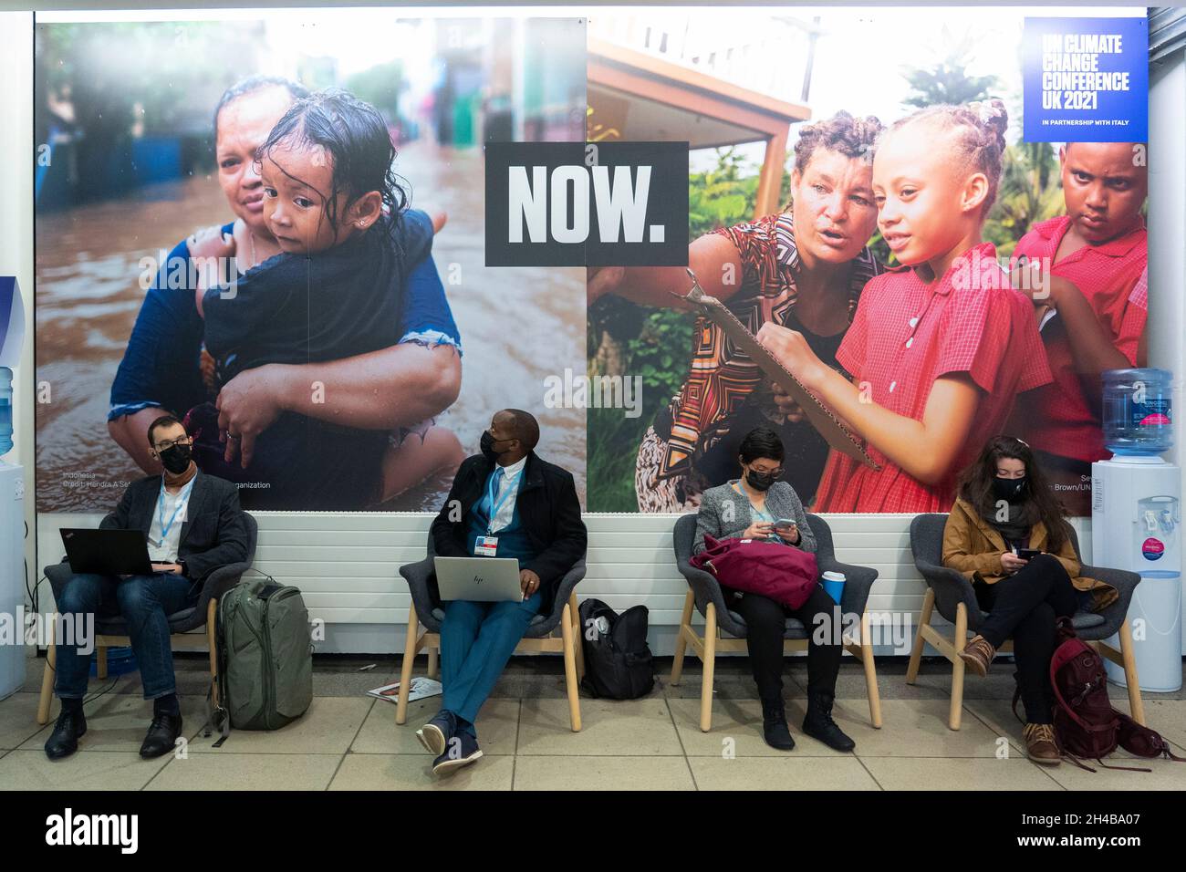 Glasgow, Scotland, UK. 1st November 2021. Images from Monday at the UN climate change conference in Glasgow. Pic; Delegates sit in front of poster at COP26 venue.  Iain Masterton/Alamy Live News. Stock Photo