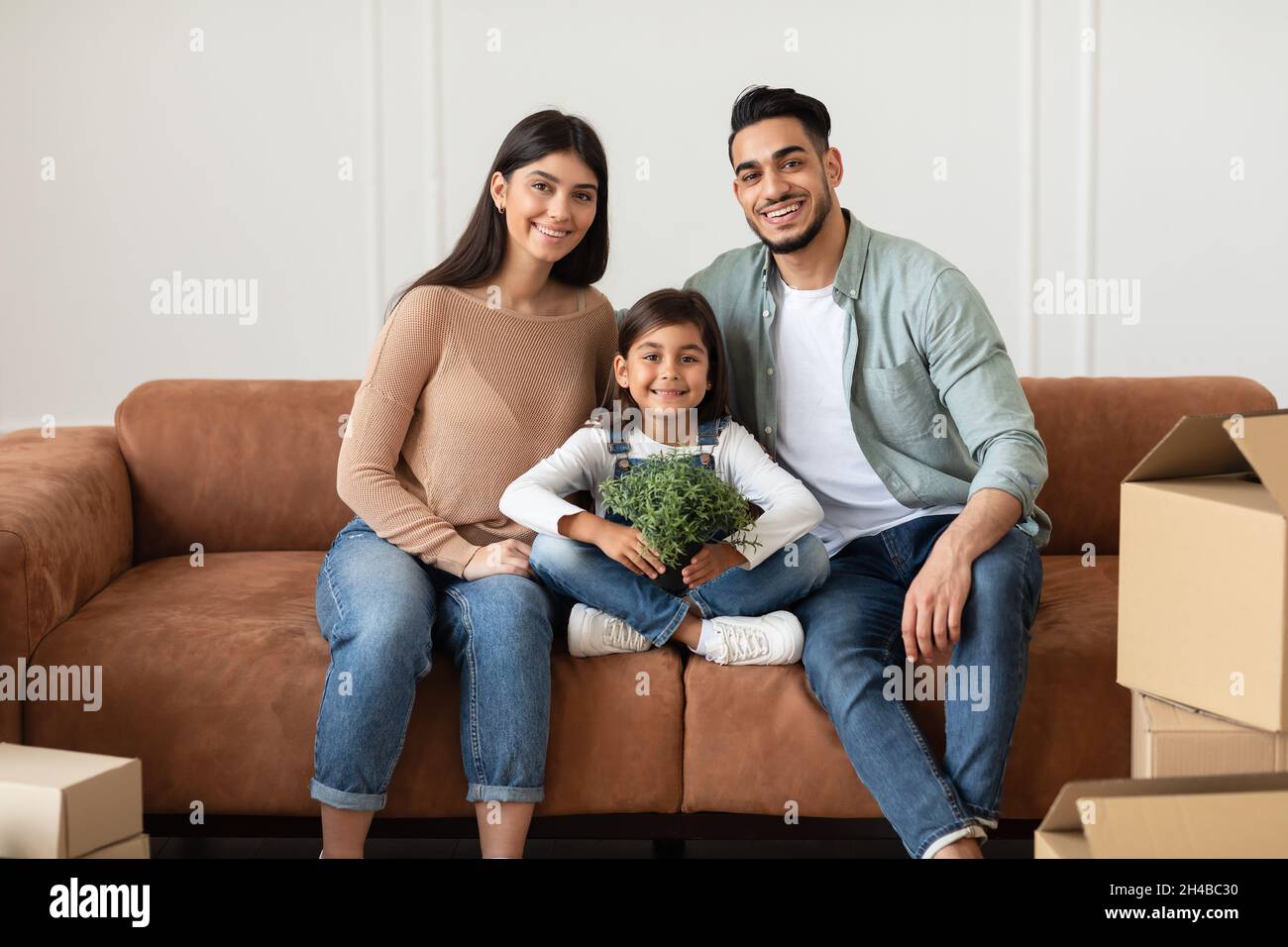 Moving Day Concept. Portrait of happy loving young mom, dad and ...