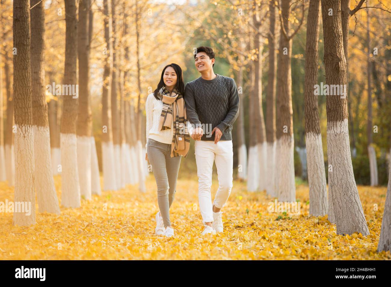 Happy young lovers walking in the woods Stock Photo